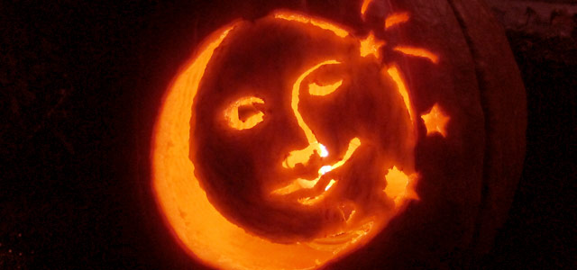 Carved, lit Jack-o-lantern with face of moon and stars Holiday & Hearth Holiday and Hearth Lisa Novelline Lisa Anne Novelline author writer The Dance of Spring craft blog creative blog creativity decorator blog festival celebration summer seasons nature blog Samhain Autumn Harvest Season Season of the Witch October Halloween reflection crow raven