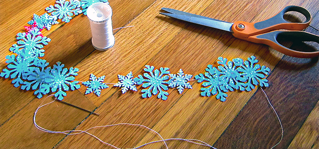 Completed Strand Of Snowflake Garland Holiday & Hearth Holiday and Hearth Lisa Novelline Lisa Anne Novelline author writer The Dance of Spring craft blog creative blog creativity decorator blog festival celebration seasons nature blog Winter Christmas Yule yuletide Winter Solstice December craft punch snowflakes garland glitter homemade handcrafted