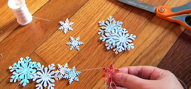 Stringing Snowflakes Into Garland Holiday & Hearth Holiday and Hearth Lisa Novelline Lisa Anne Novelline author writer The Dance of Spring craft blog creative blog creativity decorator blog festival celebration seasons nature blog Winter Christmas Yule yuletide Winter Solstice December craft punch snowflakes garland glitter homemade handcrafted